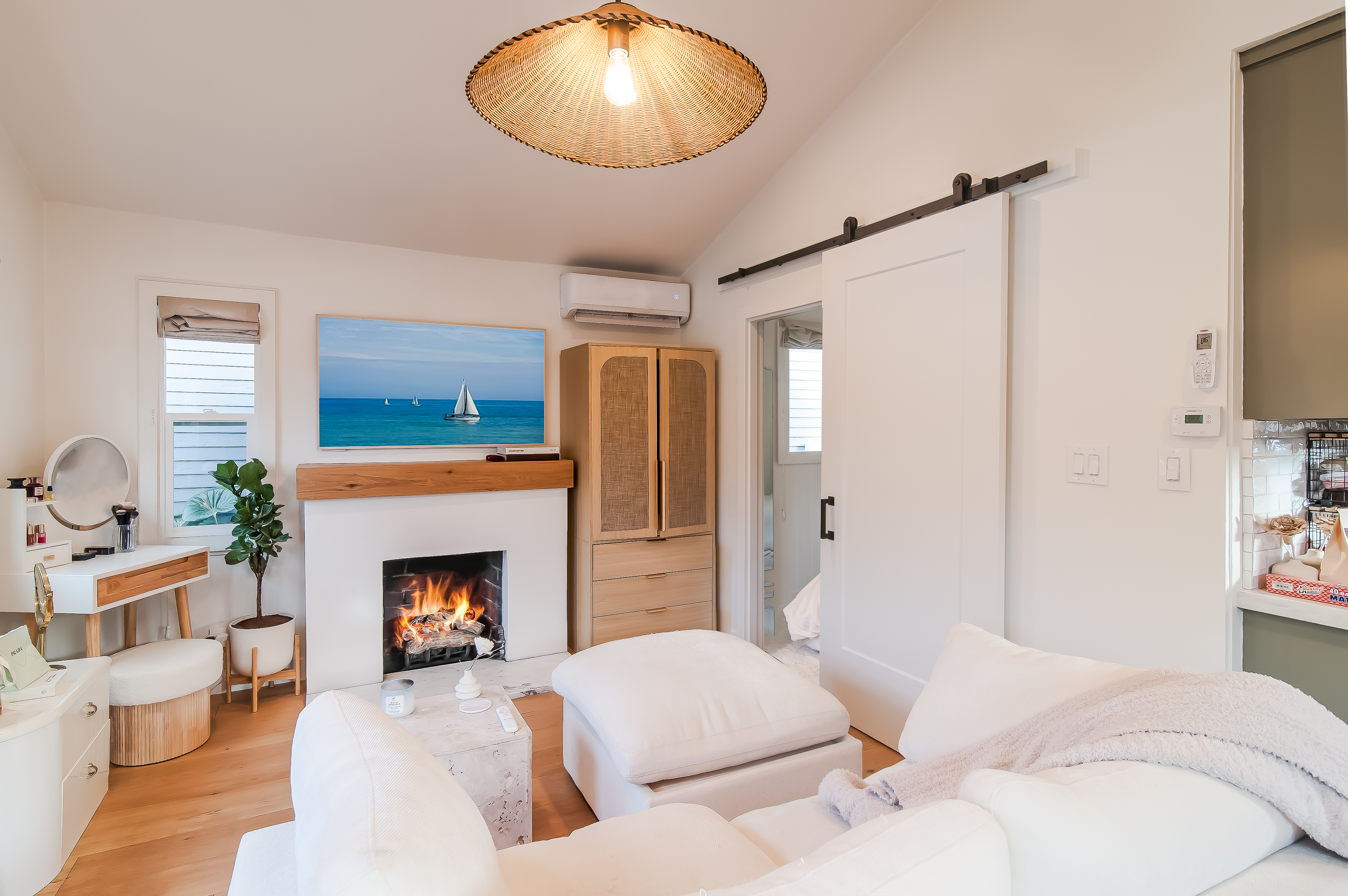 Warm cottage living room with fireplace and coastal artwork