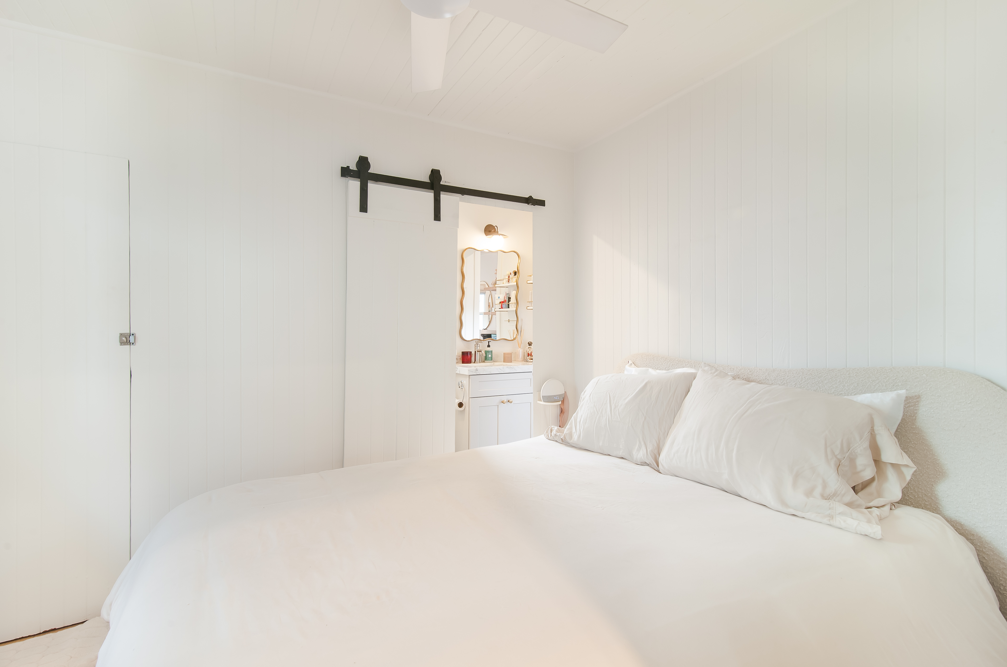 Light-filled cottage bedroom with barn door detail
