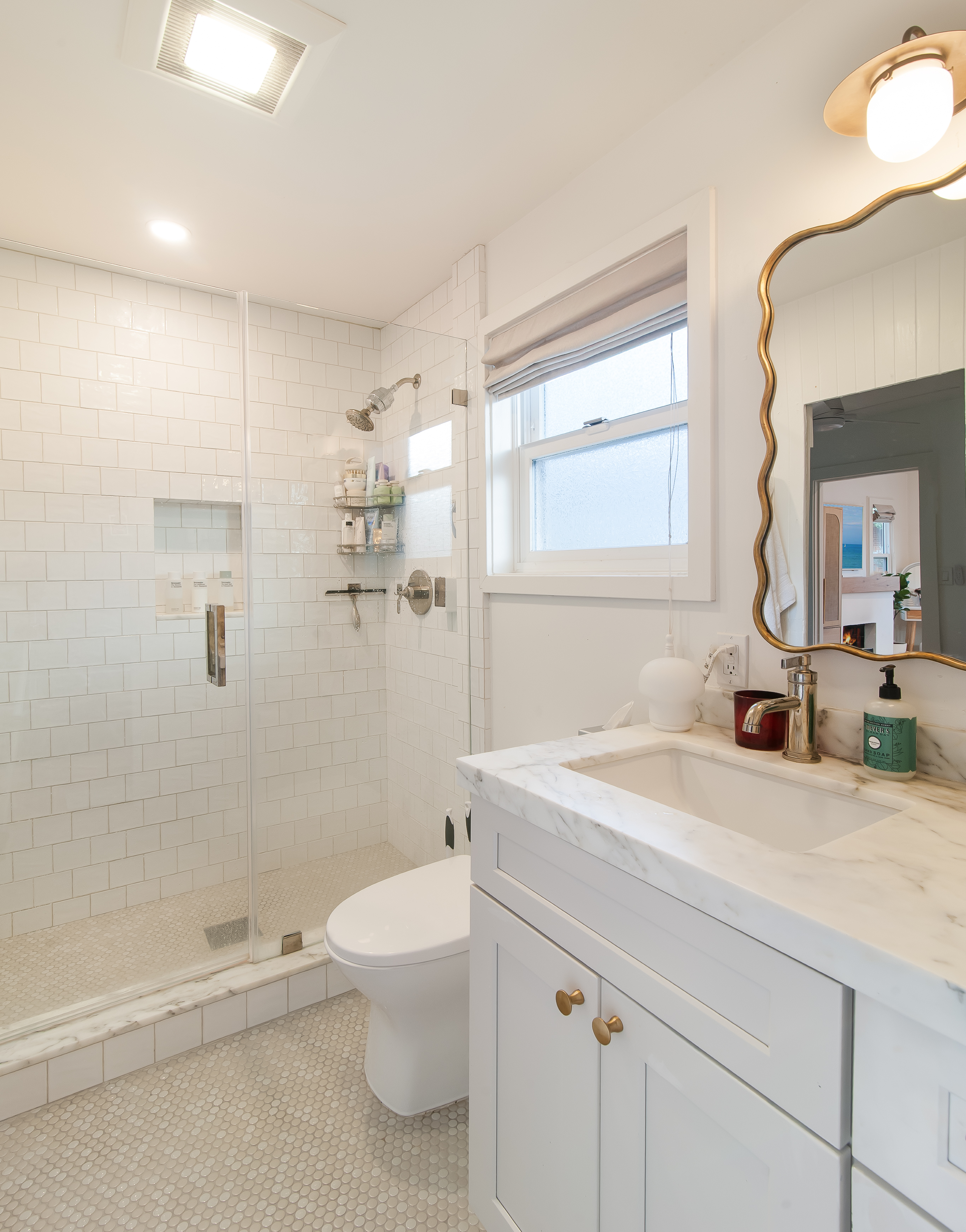 Bright cottage bathroom with marble vanity and walk-in shower